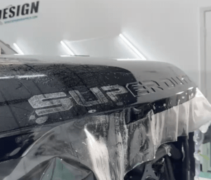 an image of paint protection film being applied on the hood of a truck